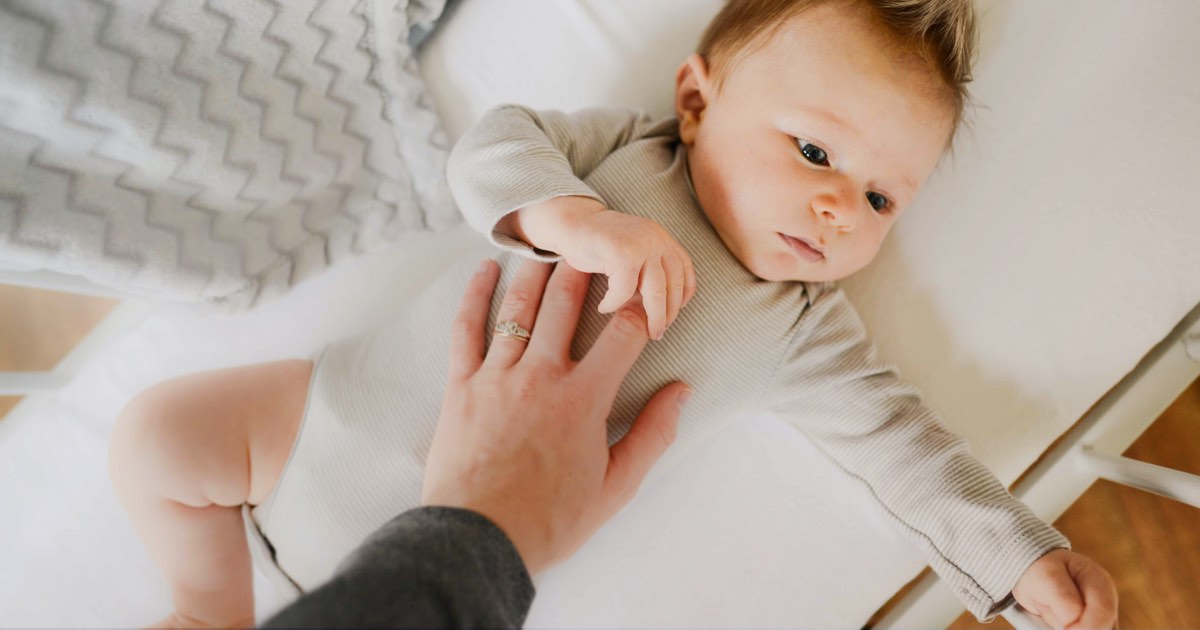 Baby liegt in Gitterbett